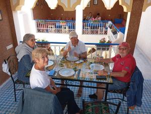 a group of people sitting at a table playing chess at Riad Ingbiwn N'Tiznit in Tiznit +14 photos