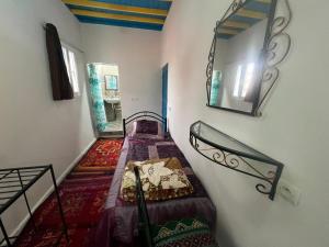 a small room with a bunk bed and a mirror at Riad Ingbiwn N'Tiznit in Tiznit