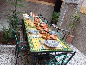 a long table with plates of food on it at Riad Ingbiwn N'Tiznit in Tiznit