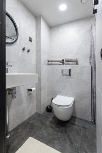 a bathroom with a white toilet and a sink at Cozy Duo Loft Studio in Tartu