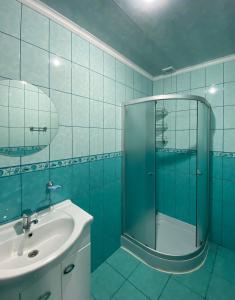 bagno blu con lavandino e doccia di ZWIN Apartment 2 a Skole