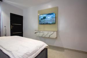 a bedroom with a bed and a tv on a wall at Love Square Platinum in Ilora +7 photos