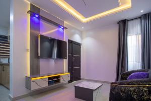 a living room with a flat screen tv on a wall at Love Square Platinum in Ilora