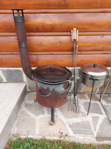a large pot and a drum sitting next to a wall at Chata vo dvore in Osturňa