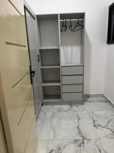 a walk in closet with marble floors and a glass door at Villa Blanche in Cotonou