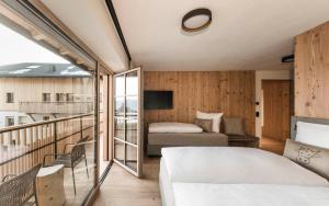 a bedroom with a bed and a balcony at Wieserhof Family Farm in Maranza