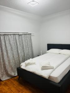 a bedroom with a bed with two towels on it at Apartament Cozy in Gherla