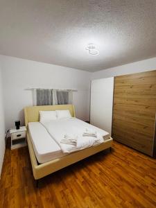 a bedroom with a bed and a wooden door at Apartament Cozy in Gherla