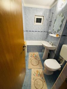 a bathroom with a toilet and a sink at Apartament Cozy in Gherla