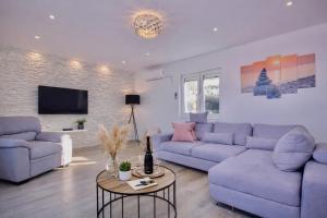 a living room with blue couches and a tv at House Gruja with Pool in Primošten