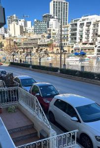 a group of cars parked on the side of a street at Seafront place Spinola StJulians in St. Julianʼs