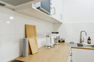 a kitchen with white walls and a wooden counter top at Olomouc Central Apartment in Olomouc +6 photos