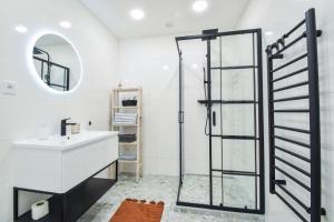 a bathroom with a glass shower and a sink at Olomouc Central Apartment in Olomouc