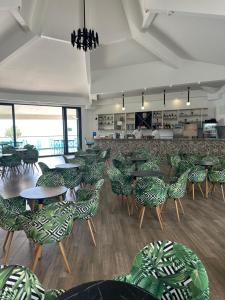 a dining room with tables and chairs and a cafeteria at Hotel SPICH - Pearl Beach Resort in Čanj