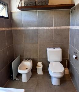 a bathroom with a toilet and a sink at La Morondanga in Villa Yacanto +22 photos