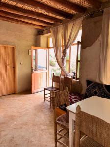 a living room with a table and chairs and a window at La Belle Etoile in Ouazzane +49 photos