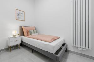 a bed in a white room with a nightstand and a bed with an orange at Yello Homes - Souterrain - Whirlpool - LuxuryStyle in Nuremberg