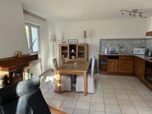 a kitchen with a wooden table and a table and chairs at Le nid du bouloir in Lisieux