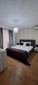a bedroom with a large bed and a chandelier at Relax Apartament in Constanţa