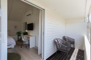 a small room with a desk and a bedroom at Spacious, Breezy Studio Apartment, Moments from Downtown and Beach in Mount Maunganui