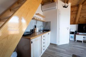 a kitchen with white cabinets and a wooden counter top at Apartmani Janjusevic in Nikšić +18 photos