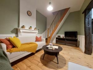 a living room with a white couch and a table at Pimpompul Vakantiewoning in Oudenaarde