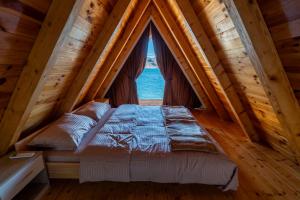 a bed in a room with a large window at Apartmani Janjusevic in Nikšić