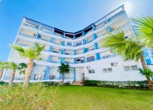 a large white building with palm trees in front of it at Cabo Dream 51 in Cabo Negro +14 photos