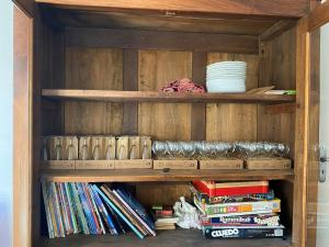 a wooden book shelf with books and plates on it at Maison familiale in Vars