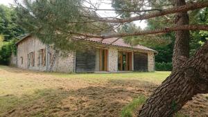 a small stone house with a tree in front of it at Maison familiale in Vars