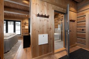 een slaapkamer met houten wanden en een deur naar een badkamer bij Nordic Gateway Logde in Hafjell +82 foto's
