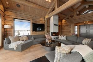 een woonkamer met een bank en een tafel bij Nordic Gateway Logde in Hafjell