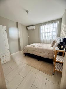 a bedroom with a bed and a window at A Hidden Gem 2BR apartment in Couva