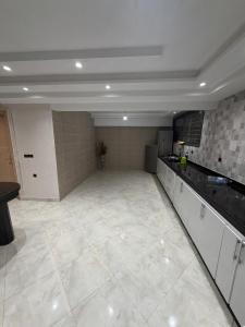 a large kitchen with white cabinets and a large tile floor at Saad's villa in Mohammedia