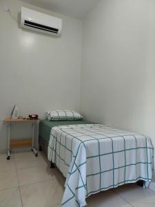 a bedroom with a bed and a desk with a air conditioner at Seis Quarto Hospedaria - Suíte Com Ar ou Ventilador - Self Checkin - Centro in Juazeiro do Norte