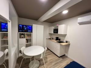 een kleine keuken met een witte tafel en stoelen bij Residence della Accademia in Modena