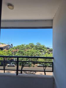 a window with a view of a street and trees at Tres habitaciones Cómodo Residencia in Encarnación