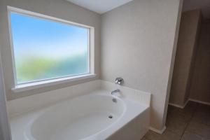 een badkamer met een wit bad en een raam bij Crew Stay Sleeps 16 Work, Cook, Play & Relax in Navo +12 foto's