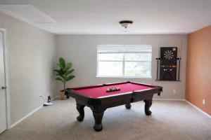 een rode pooltafel in een kamer met een raam bij Crew Stay Sleeps 16 Work, Cook, Play & Relax in Navo