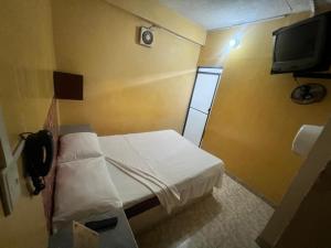 una piccola stanza con un letto e una televisione di Hotel Ensueño a Pereira Altre 66 foto
