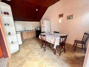 een keuken met een tafel met stoelen en een koelkast bij Cabañas Brisa's in Santa Vitória do Palmar +9 foto's