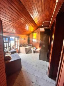 a living room with a wooden ceiling and a couch at Cabañas Brisa's in Santa Vitória do Palmar