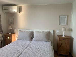 a bedroom with a white bed with two night stands at Suite Incanto lago di Garda in Torri del Benaco