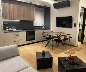 a living room with a table and a kitchen at Philoxenia by nature in Karkaloú