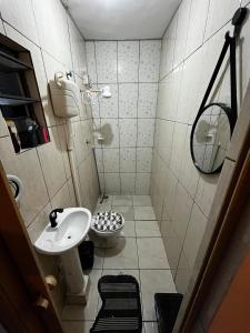 een kleine badkamer met een wastafel en een toilet bij Casa aconchegante in Belfort Roxo