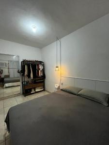 een slaapkamer met een bed en een kledingrek bij Casa aconchegante in Belfort Roxo