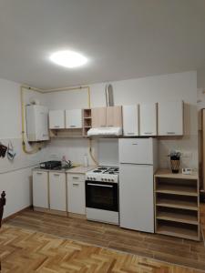 a kitchen with white cabinets and a stove top oven at STAN NA DAN Stara Pazova in Stara Pazova
