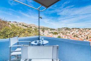 a table and chairs on a balcony with a view at Symi Traditional Appartment in Symi