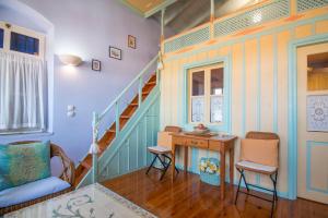 a room with a staircase with a table and chairs at Symi Traditional Appartment in Symi