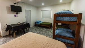 a room with a bunk bed and a table and a desk at El jacaranda Alojamiento Diario in San Luis +63 photos